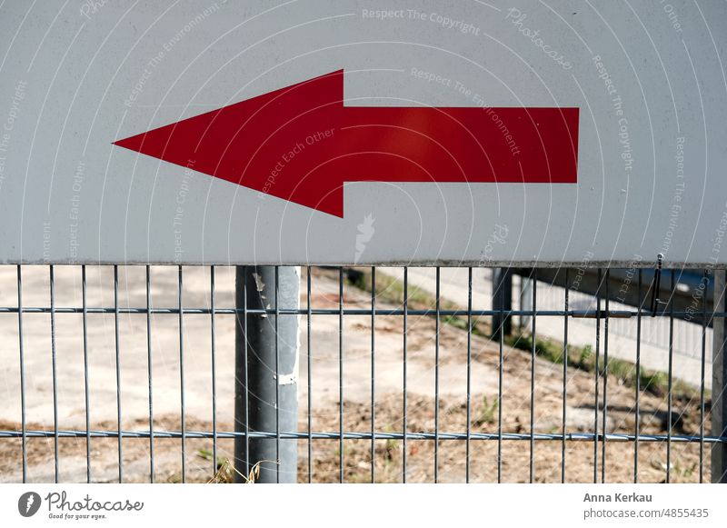 Left long-a red arrow attached to a metal grate shows the way Red Arrow Signage in a certain direction Direction Reddish white groundbreaking Left arrow