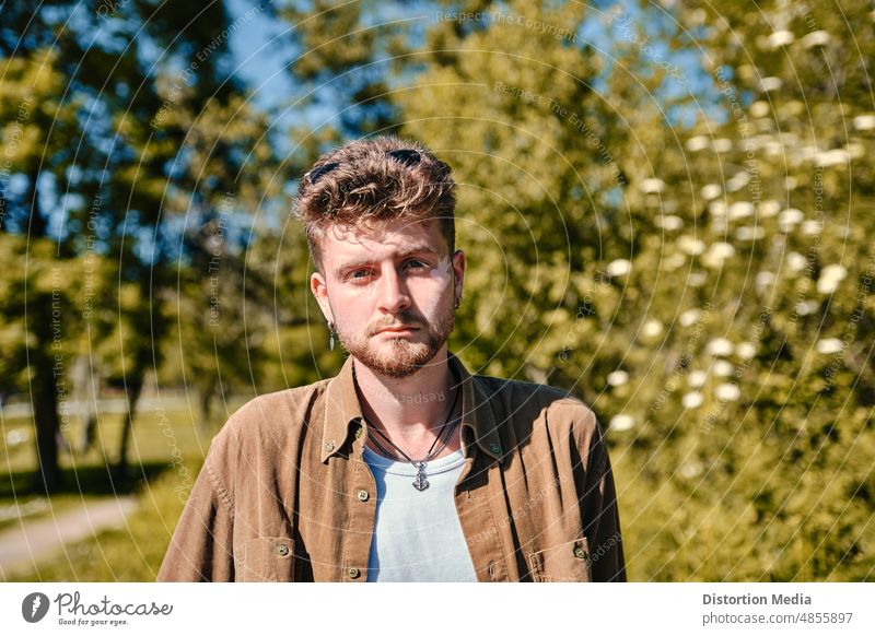 Portrait of a trendy boy with sad expression on a green meadow facial expressions lifestyle professional gentleman caucasian casual attractive attitude handsome