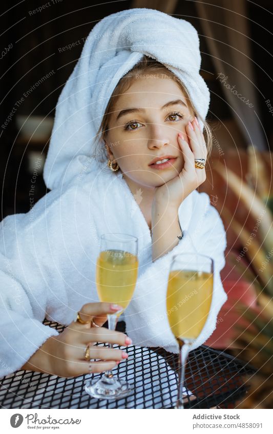 Woman in towels drinking cocktail on terrace woman morning patio hobby leisure juice beverage feminine summer glass table female style summertime thoughtful