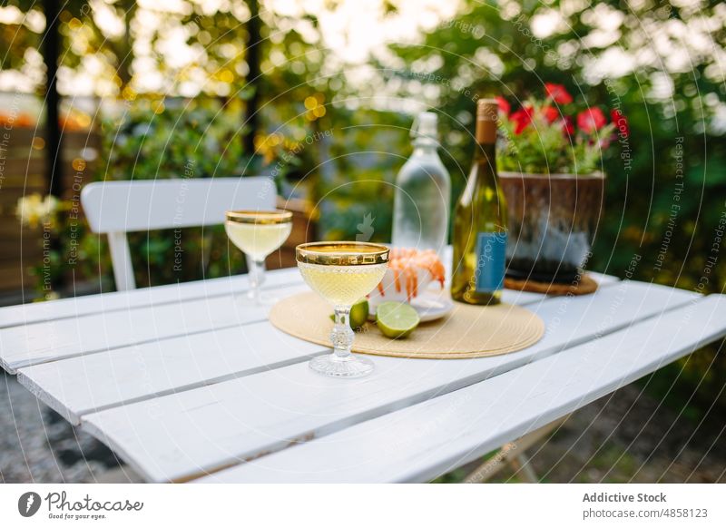 Champagne glasses on table with shrimps champagne seafood alcohol terrace patio backyard countryside booze aperitif bottle serve drink beverage style occasion