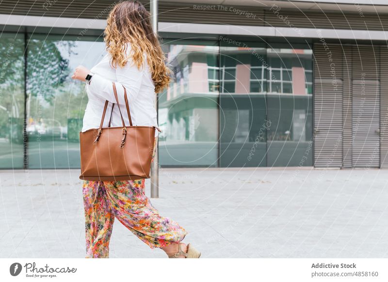 Woman walking near modern building woman street city appearance style urban fashion feminine female house glad wall construction town summer lady charming