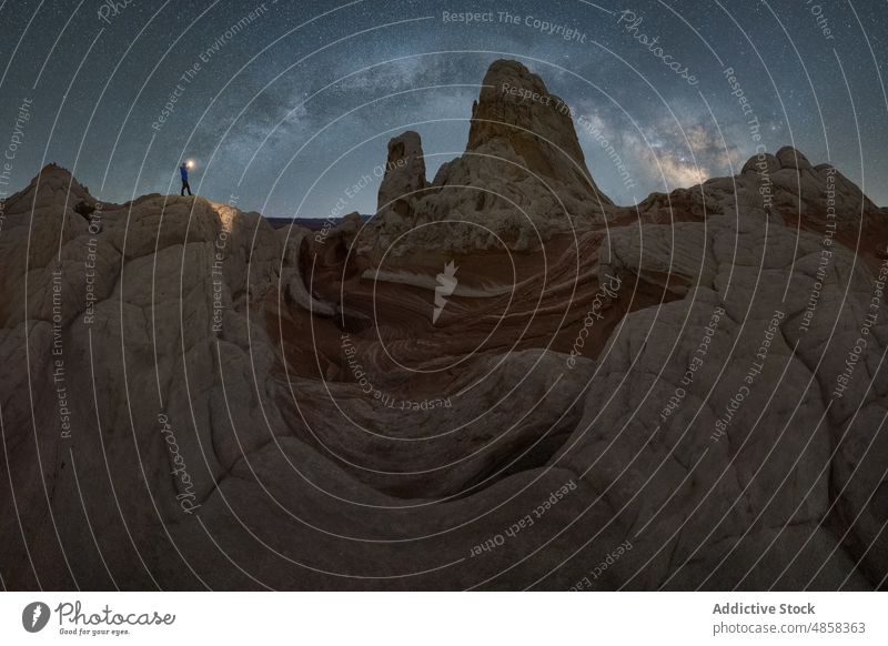 Anonymous traveler standing on stone on mountain with milky way on sky vermillion canyon cliffs landscape night arizona desert usa outdoors nature star monument