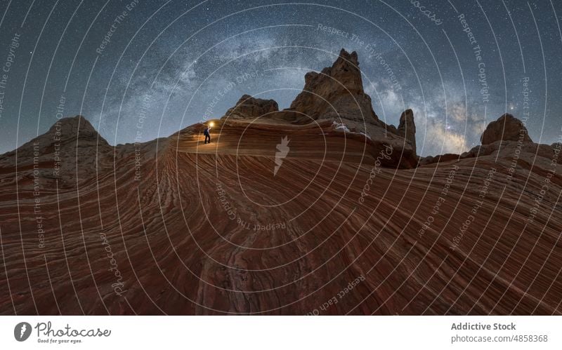 Anonymous traveler standing on stone on mountain with milky way on sky vermillion canyon cliffs landscape night arizona desert usa outdoors nature star monument