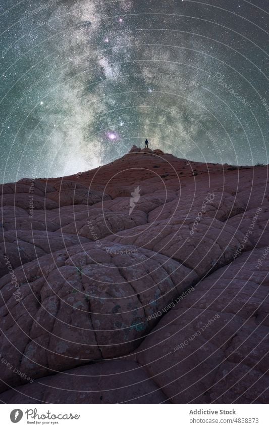 Anonymous traveler standing on stone on mountain with milky way on sky vermillion canyon cliffs landscape night arizona desert usa outdoors nature star monument