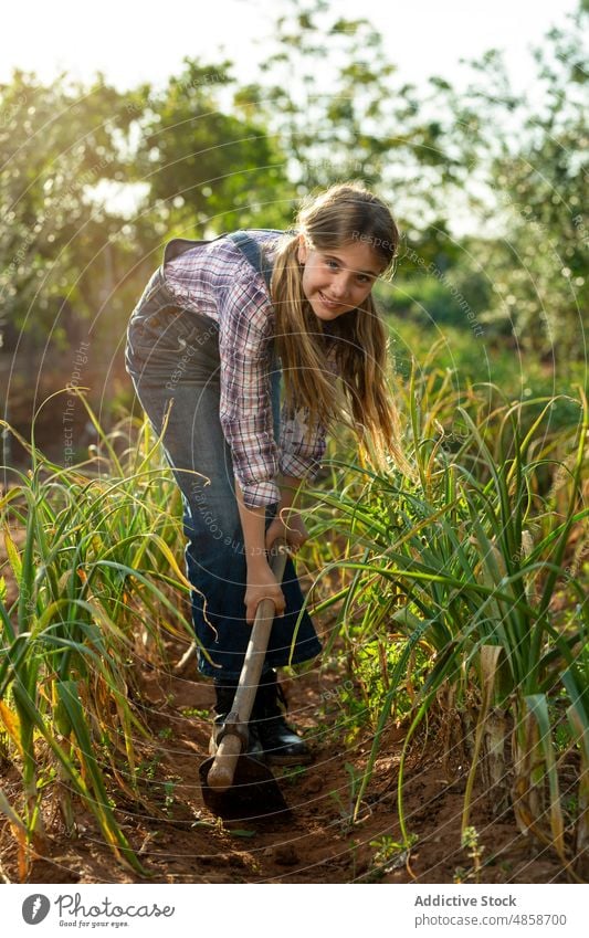 Girl hoeing soil near spring onion girl scallion field gardener farm weed remove summer agriculture countryside rural cultivate daytime flora child agronomy dig