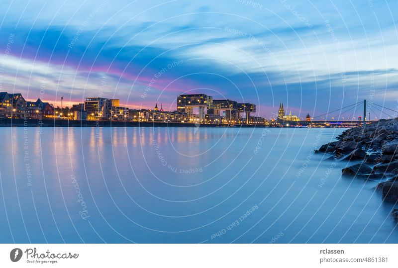 Cologne city panorama with cathedral and crane houses at sunset abundance architecture dusk clouds sky attraction night light blue boat bridge building church