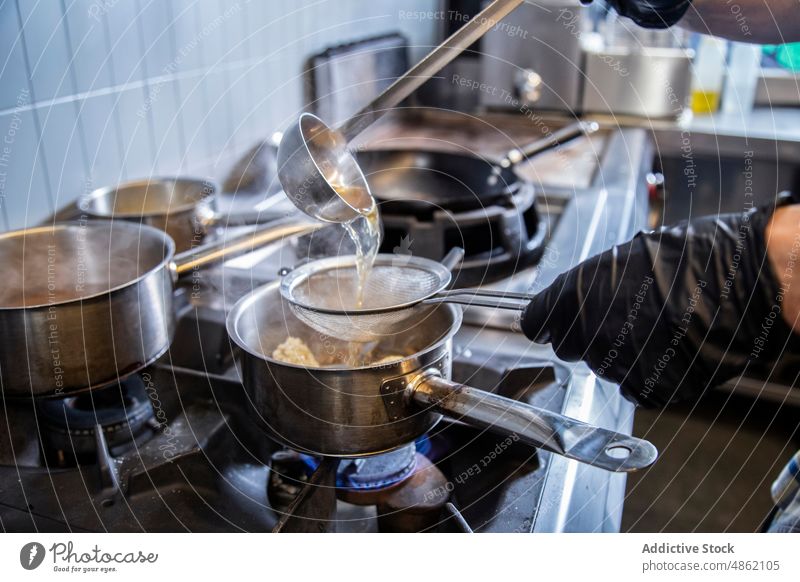 Chef Separating Water From Rice Using Strainer In Kitchen Commercial Pouring Stewpan Stove Utensil Industrial Cooking Preparing Food Ladle Saucepan Boiling