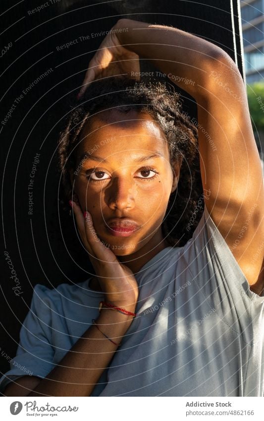 Thoughtful young ethnic woman looking at camera near window pensive calm dreamy sunlight thoughtful tranquil portrait contemplate serious alone female