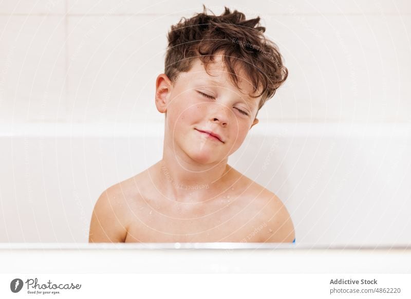 Boy with closed eyes sitting in bathtub boy kid child hygiene routine sleep bathroom portrait clean everyday daily childhood carefree at home calm serene