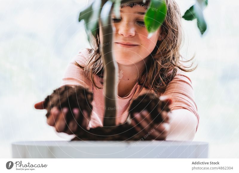 Girl pouring soil into flowerpot girl kid transplant gardener cultivate care grow potted replant room flora botanic floral vegetate natural child flat housework