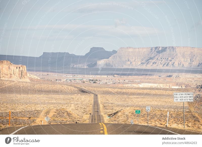 Scenic mountain in between asphalt highway cliffs utah national park landscape road roadway cloudy travel butte rocky outcrop Navajo Tribal Park desert usa