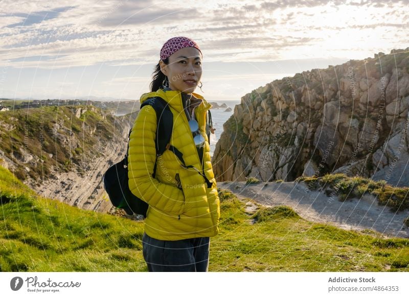 Asian girl hiking along the coast in Spring during the sunset active activity adventure alone asian asian girl background backpack beautiful camping dark hair