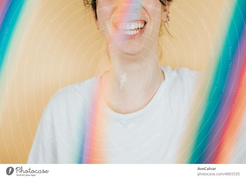 Young woman smiling happily to camera while holding a LGBTIQ flag waving to camera. Lesbian woman, pride and fighting for her rights. Love is love concept.