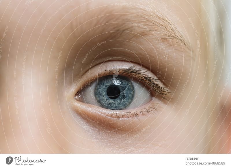 Closeup of beautiful girl with open blue eye. Beautiful blue eyes macro shot. image of a little kid eye open baby health child care family light background