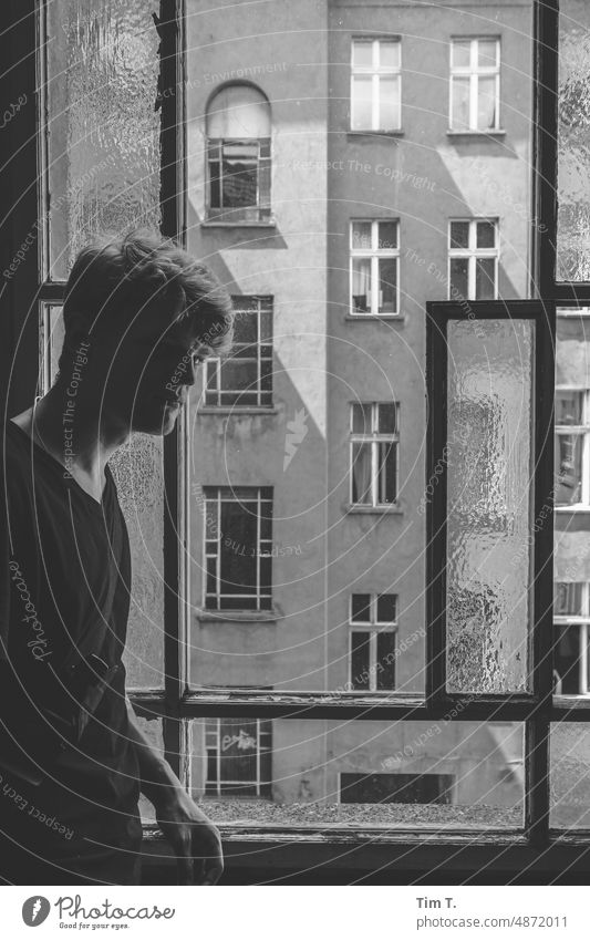 a young man at the staircase window Old building unrefurbished Staircase (Hallway) bnw Black & white photo Prenzlauer Berg Window Interior courtyard b/w Man