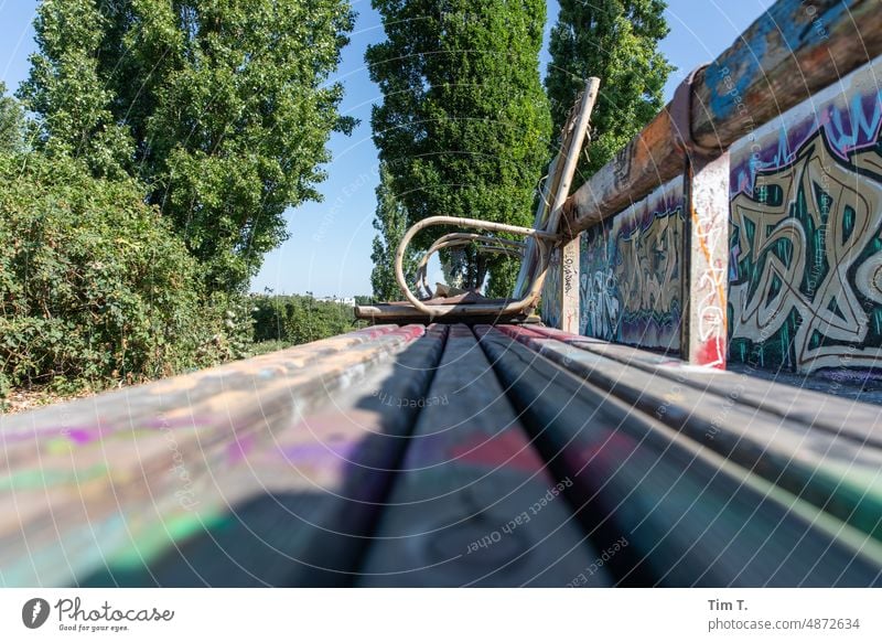 a chair on a bench in Mauerpark wall park Prenzlauer Berg Bench Berlin Capital city Exterior shot Park Town Deserted Downtown Colour photo Day blurriness