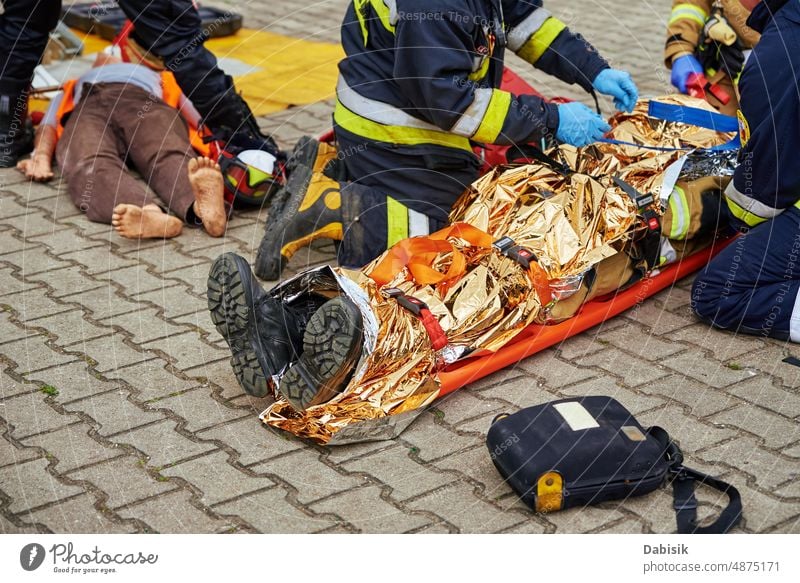 Rescuers provide first aid to the victim during car road accident corpse body dead police firefighter rescuer bag black caution killed motorway tape assistance