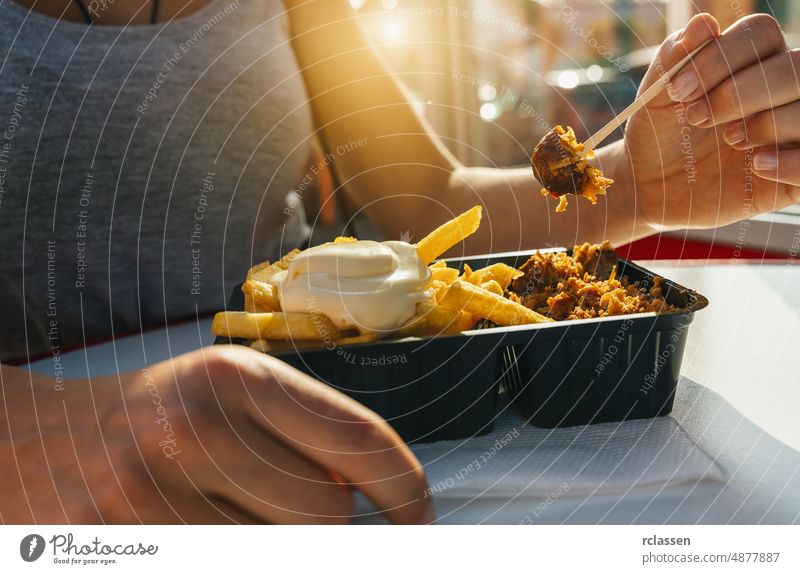 German Currywurst sausage with curry ketchup, roasted onions and French fries with mayonnaise in the city currywurst food french fries curry powder germany