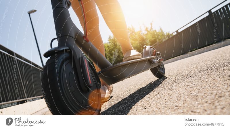 Young woman is ready to discover the urban city at a summer day with electric scooter or e-scooter, Electric urban transportation concept image kick downtown