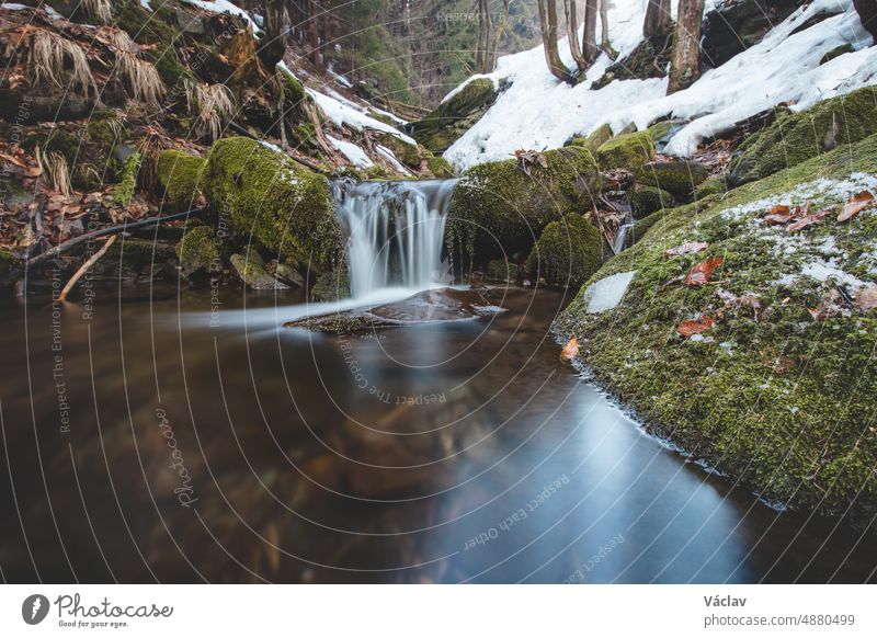 Frosty ice cascades in the Beskydy Task in the east of the Czech Republic in the middle of Europe. Naturally created waterfalls on a rock formation with crystal clear water