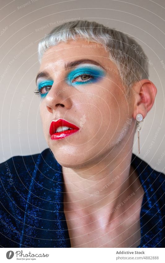 Portrait Of Transgender Man With Makeup Eye Shadow Gay Posing Queer Fashion Individuality LGBTQI Closeup Pride Studio Shot Feminine Red Lipstick Background