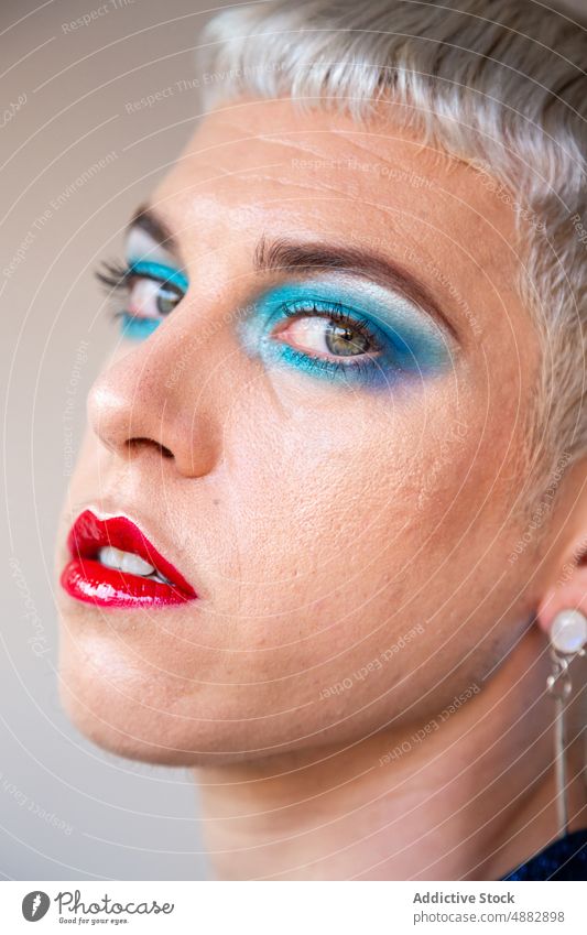 Portrait Of Transgender Man With Makeup Eye Shadow Gay Posing Queer Fashion Individuality LGBTQI Closeup Pride Studio Shot Feminine Red Lipstick Background