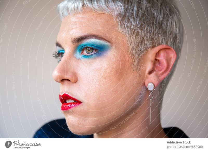 Portrait Of Transgender Man With Makeup Eye Shadow Gay Posing Queer Fashion Individuality LGBTQI Closeup Pride Studio Shot Feminine Red Lipstick Background