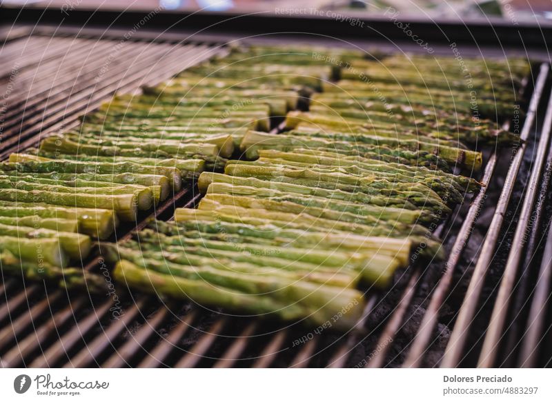 Lots of fresh asparagus simmering on a grill appetizer barbecue barbeque bbq bunch calories closeup colorful cook cooked cooking cuisine diet dinner entrecote