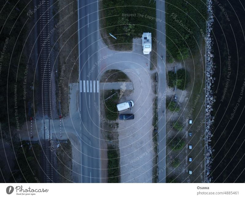 Parking lot by the sea Street Railroad tracks rails Control barrier cars Transport coast Ocean Rail transport Exterior shot Means of transport Aerial photograph