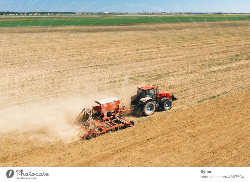 Aerial View. Tractor With Seed Drill Machine Sowing The Seeds For Crops In Spring Season. Beginning Of Agricultural Spring Season. Countryside Rural Field Landscape