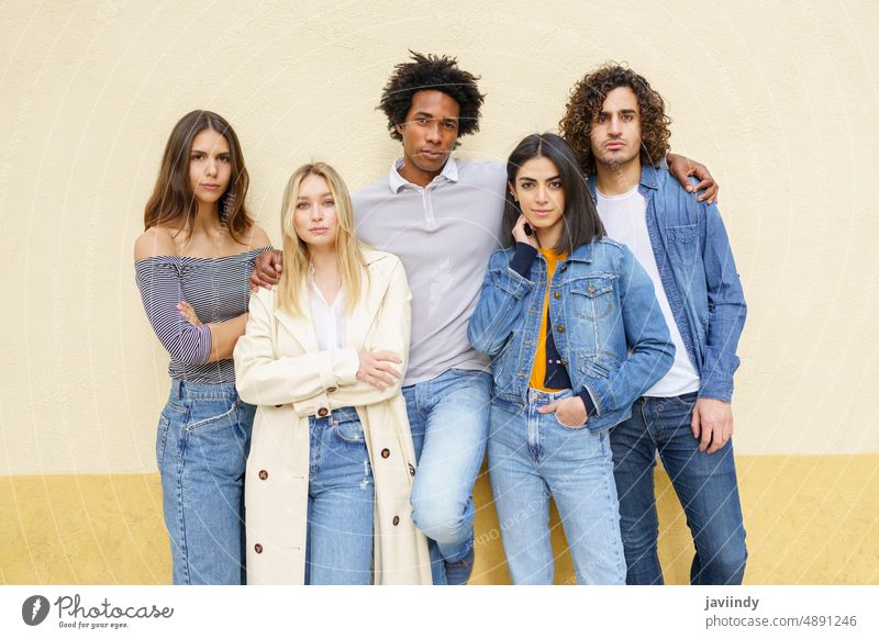 Multi-ethnic group of friends posing together outdoors multi-ethnic people diversity student multiracial outside street urban men women afro serious students