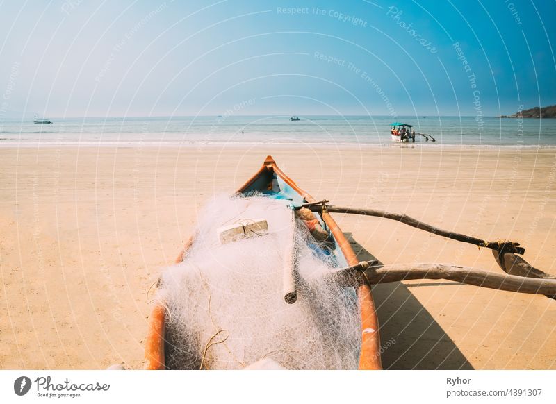 Canacona, Goa, India. Wooden Fishing Boat With Net Parked On Famous Palolem Beach In Summer Sunny Day asia beach beautiful boat coast famous fishing boat india