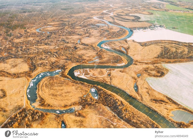 Aerial View Of Dry Grass And Partly Frozen River Landscape In Late Autumn Day. High Attitude View. Marsh Bog. Drone View. Bird's Eye View aerial aerial view