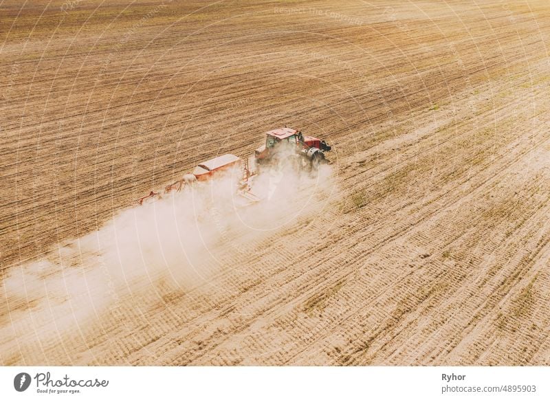 Aerial View. Tractor With Seed Drill Machine Sowing The Seeds For Crops In Spring Season. Beginning Of Agricultural Spring Season. Countryside Rural Field Landscape