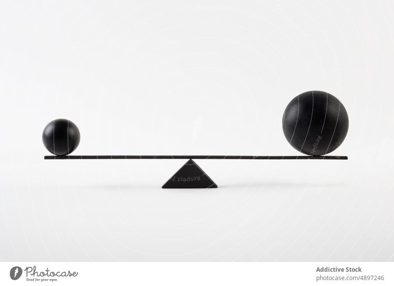 Black balls balancing on scales balance geometry minimal design concept element modern contrast small big size composition equilibrium symbol round sphere