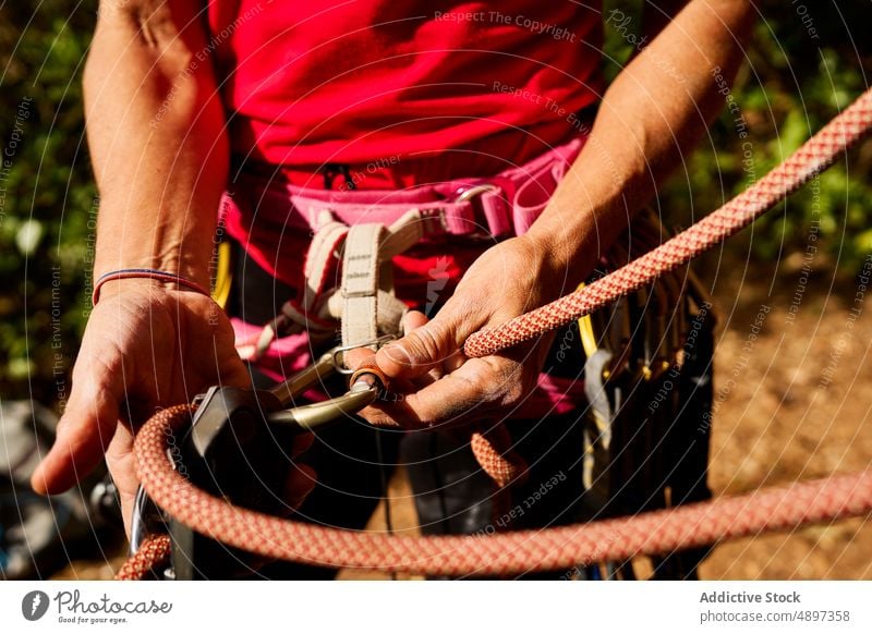 Anonymous Senior Woman Tying Rope On Waist Female Active Climber Harness Midsection Standing Hiker Adventure Retirement Hiking Fitness Aged Athlete Activity