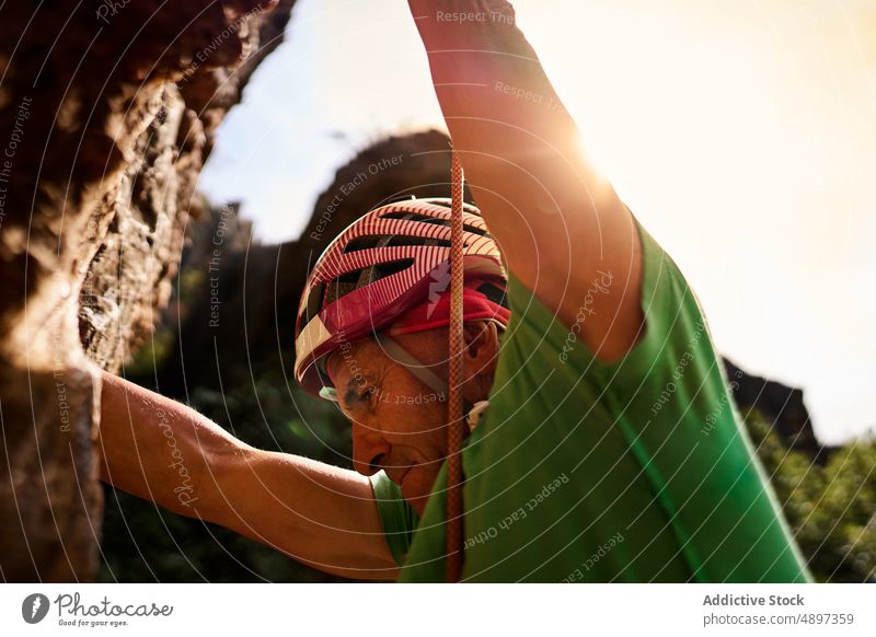 Man Climbing On Rocky Cliff man Active Low Angle Climber Hiker Harness Adventure Danger Hiking Fitness fit Athlete Activity Vacation Senior Risk Challenge