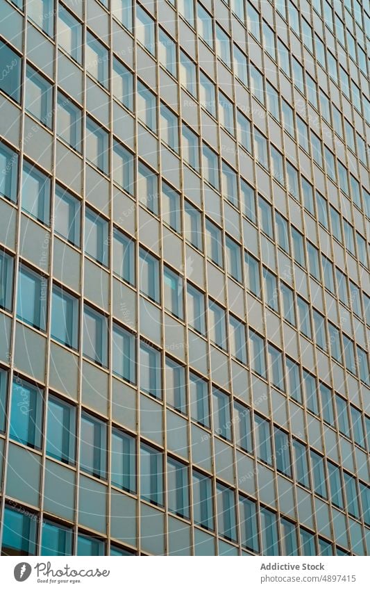 Geometric building with mirrored windows facade skyscraper architecture exterior multistory infrastructure futuristic glass wall reflection construction dense