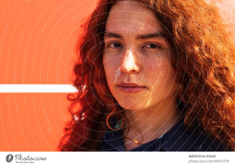 Woman With curly hair Redhead Curly Hair Beautiful Sunlight Wall Lifestyle Arm Raised Leisure Tshirt Attractive Expression Front View Headshot Sunny Confidence