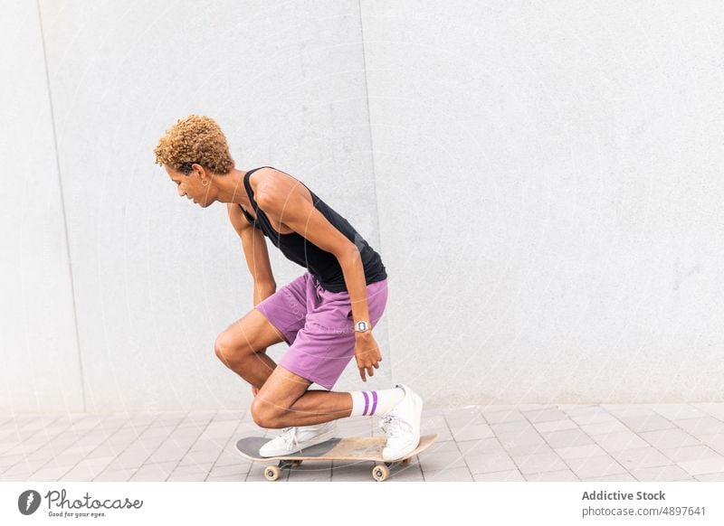 Black man riding skateboard on street ride pathway skateboarder hobby training sport pastime healthy lifestyle move walkway pavement african american sidewalk