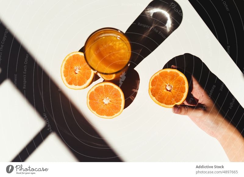 Crop woman taking orange juice glass morning diet vitamin c healthy drink sunlit table half squeeze detox fresh fruit breakfast ripe citrus organic natural