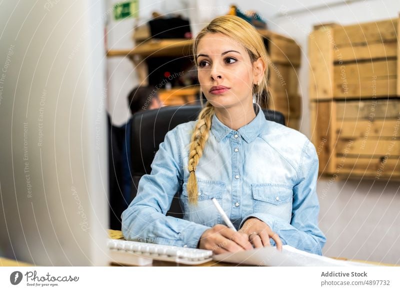 Joyful woman working with document and computer typing browsing office workplace project business businesswoman using formal positive female surfing career