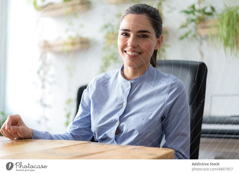 Happy businesswoman sitting near table smile office happy break at work rest portrait female workplace cheerful optimist daytime job entrepreneur workspace