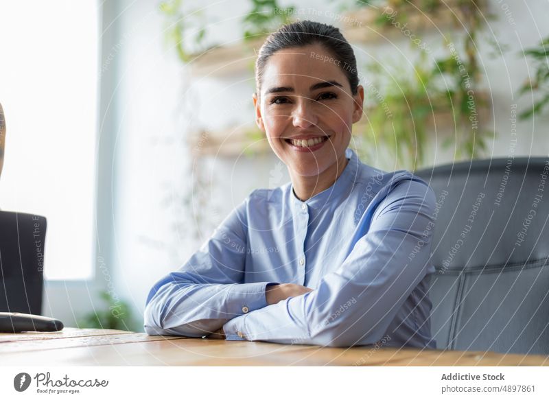 Happy businesswoman sitting near table smile office happy break at work rest portrait female workplace cheerful optimist daytime job entrepreneur workspace