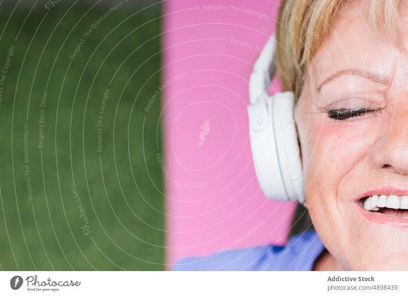 Senior Woman Listening Music Meditating On Yoga Mat Eyes Closed Lying Headphones smile Top View Meditate Calm Healthy Lifestyle Sporty Active Wireless Face