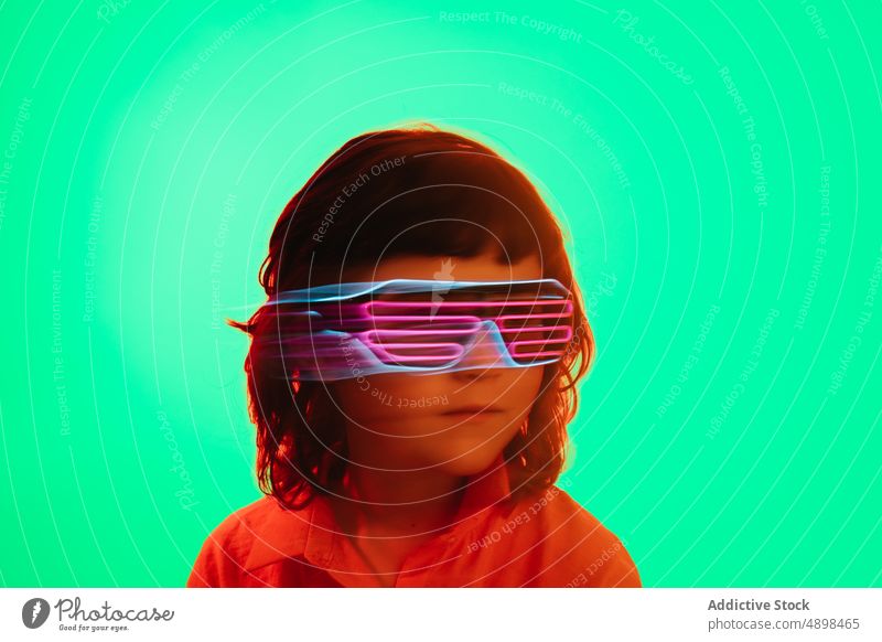 Little kid in neon glasses futuristic party goggles colorful bright childhood glow costume little vibrant festive event cute adorable sci fi appearance