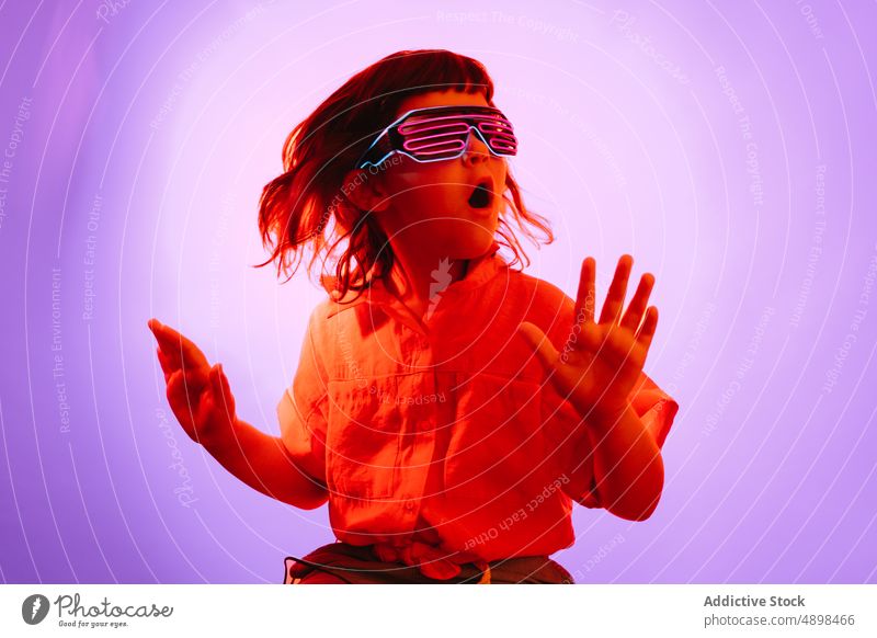 Little kid in neon glasses futuristic party goggles colorful bright childhood glow costume little vibrant festive event cute adorable sci fi appearance