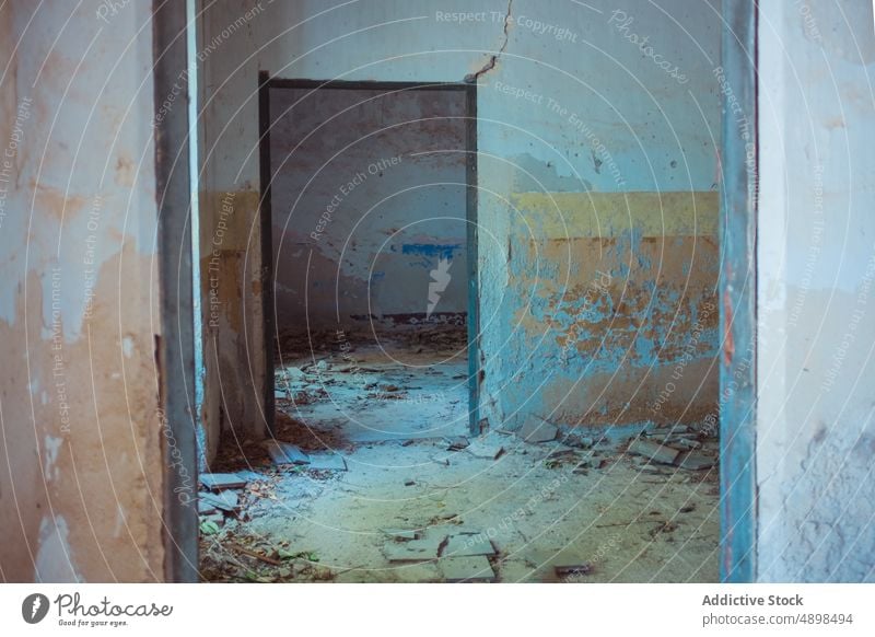 Interior of desolate apartment building interior corridor abandoned wall shabby doorway crumble plaster weathered hallway structure grunge construction decay