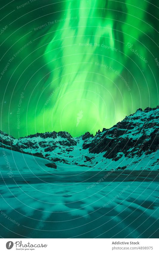 Steep snowy mountains under starry sky and northern lights cliff rock night landscape island glow range polar aurora borealis nature scenery stone scenic