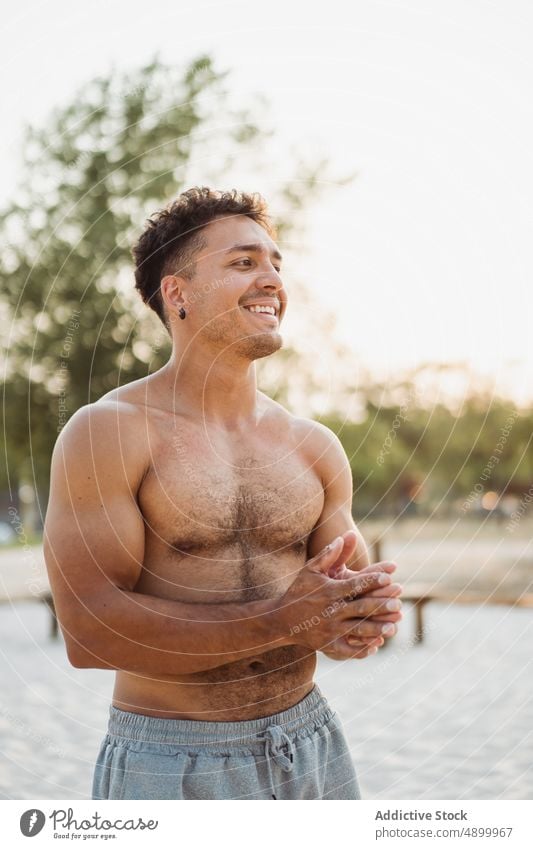 Sportsman rubbing sands on hands sportsman happy calisthenics smile hispanic training prepare beach powder latin athlete exercise ethnic sports ground confident